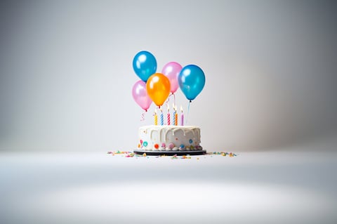 White birthday cake with colorful balloons