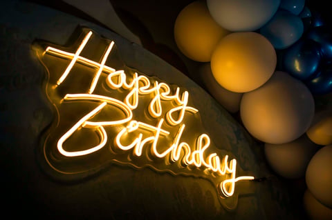 Glowing neon happy birthday sign at festive celebration