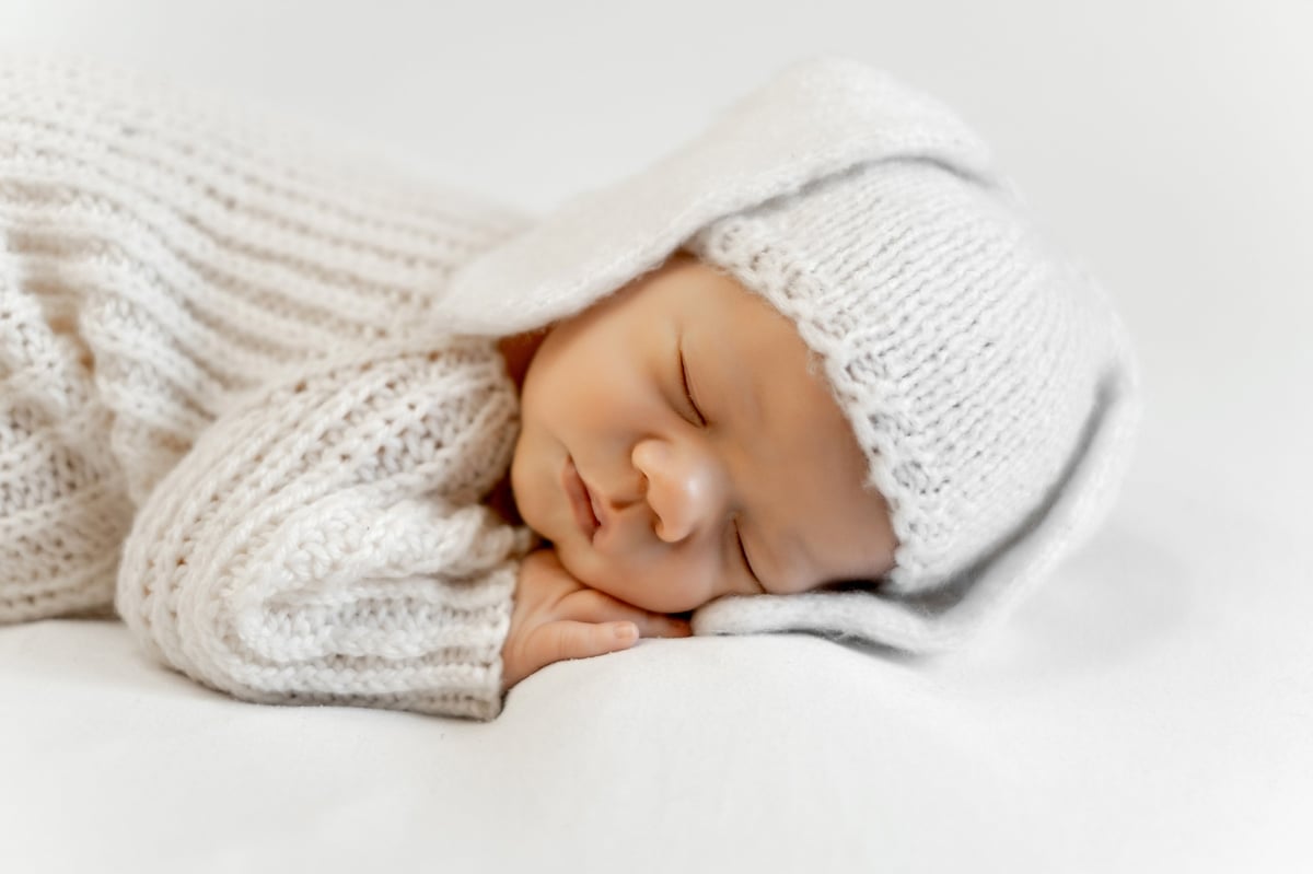 A newborn baby on a white isolated background, a sleeping baby, and space for text