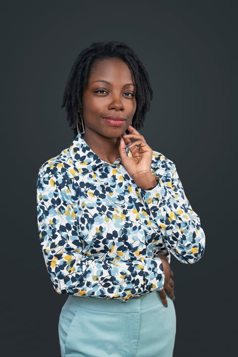 Mujer con dreadlocks usando blusa estampada azul y amarilla con falda azul claro